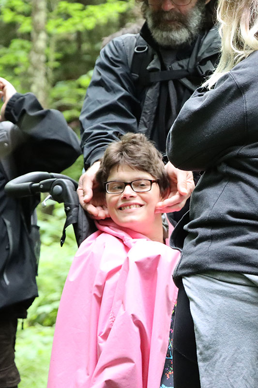 Girl in wheelchair in nature smiling Adirondack Nature Festival for People with Disabilities